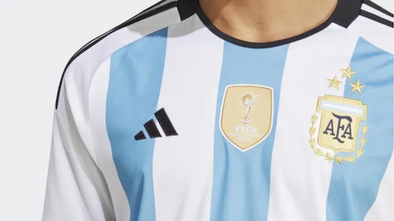 Detalle de la camiseta oficial de la Selección Argentina con tres estrellas y el escudo de campeones del mundo