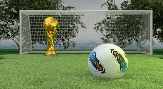 Balón de fútbol frente al trofeo del Mundial en una cancha al aire libre