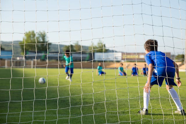 Niño arquero en posición frente a un penal durante un entrenamiento de fútbol infantil