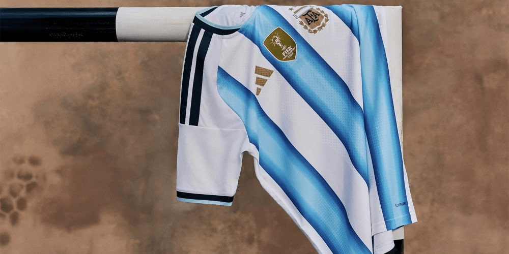 Camiseta de la selección argentina para el Mundial 2026 con franjas celestes y blancas colgada en un arco de fútbol