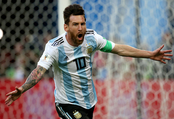 Futbolista argentino con la camiseta de la selección celebrando un gol durante un partido internacional.