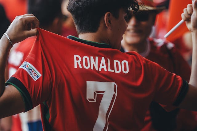 Aficionado con una camiseta roja que lleva el nombre y número 7 de Ronaldo durante un evento deportivo.
