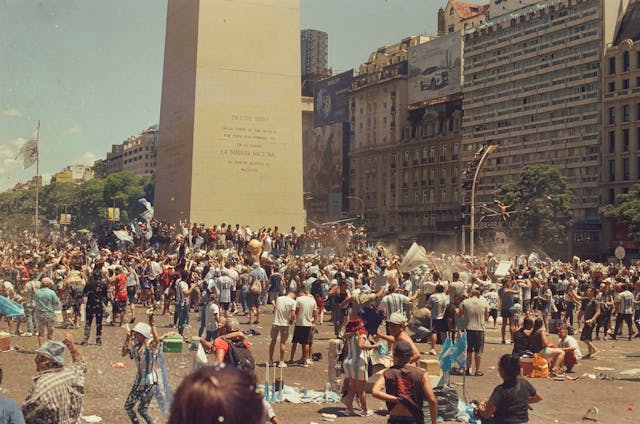 Multitud de hinchas argentinos celebrando en el Obelisco con banderas celestes y blancas.