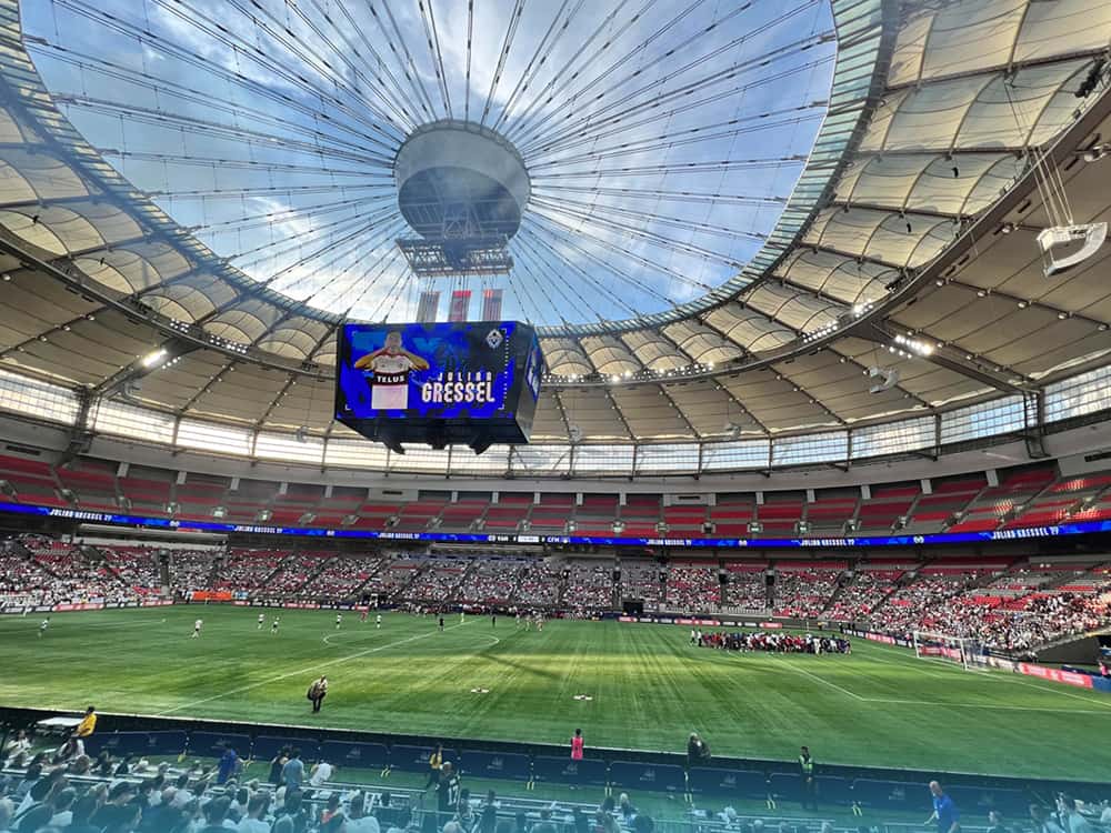 Interior del BC Place en Vancouver durante un partido, una de las sedes del Mundial 2026, con el techo retráctil y el estadio lleno de público.